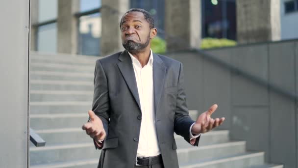 Şaşırmış Afro Amerikalı Yetişkin Adam Ellerini Açar Omuz Silker Dışarıda — Stok video