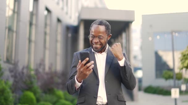 Smiling African American Businessman Glasses Reading Good News Smartphone While — Stock video