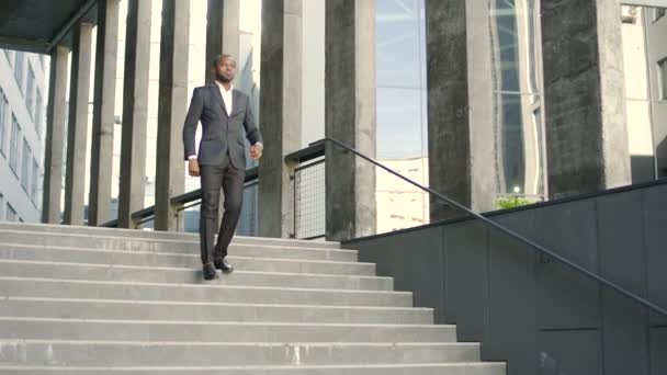 Egy Komoly Afro Amerikai Üzletember Lassan Sétál Egy Irodaház Lépcsőjén — Stock videók