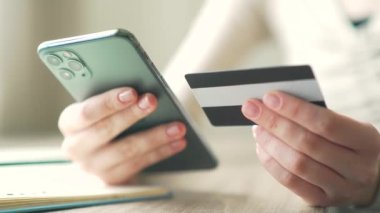 Kadının el yapımı ödemesini kredi kartı ve cep telefonu kullanarak kapatın. Kapatın. Genç bayan çevrimiçi bankacılık siparişi.