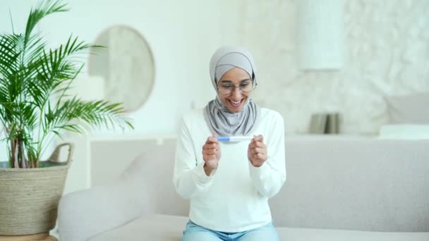 Νεαρή Μουσουλμάνα Μαντίλα Που Κοιτάζει Θετικά Τεστ Εγκυμοσύνης Και Χαίρεται — Αρχείο Βίντεο