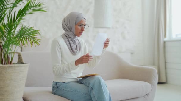 Стрессовая Мусульманская Молодая Женщина Хиджабе Открывает Конверт Письмом Финансовых Проблемах — стоковое видео