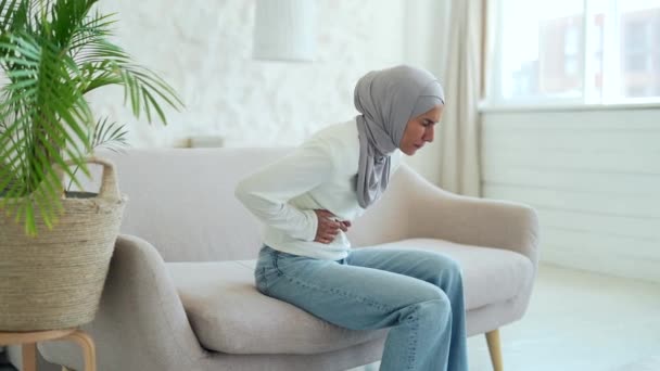 Doente Jovem Muçulmana Hijab Sofrendo Dor Estômago Sentado Sofá Segurando — Vídeo de Stock