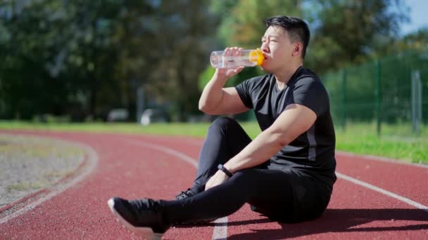 Щасливий Молодий Дорослий Азіатський Спортсмен Воду Пляшки Сидячи Біговій Доріжці — стокове відео