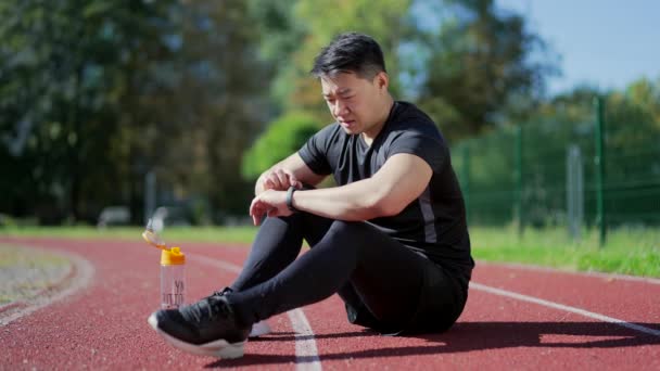 Asyalı Koşucu Şehir Stadyumunda Koşu Bandında Dinleniyor Kronometreyi Akıllı Gözlemde — Stok video