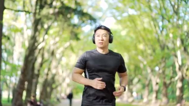 Young Adult Asian Runner Headphones Jogging Urban City Park Handsome — Stock videók