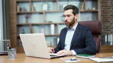 Smiling friendly mature business man investor looking at computer screen greeting and talking by online meeting conference video call using webcam at workplace indoors Working conversation concept