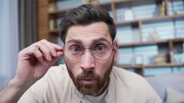 안경을 카메라를 응시하고 턱수염 남자의 모습은 집에서 갑작스런 놀라운 판매에 — 비디오
