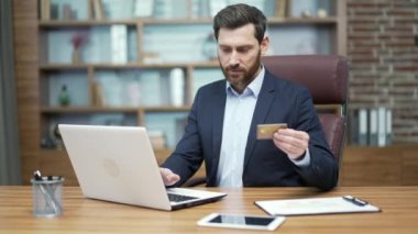 Nervous entrepreneur with credit card has problem with online order bad service blocked bank account Stressed bearded business man doing internet shopping failure with money transfer payment on laptop