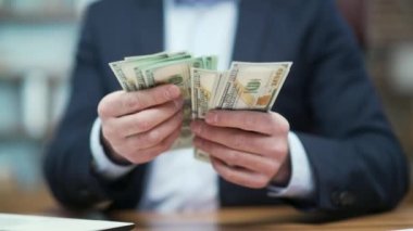 Modern ofisteki banknotları sayan iş adamı yatırımcılarının ellerini kapat. Başarılı girişimci para tutuyor ve işyerindeki iyi kazanç maaşı yatırımından memnun.