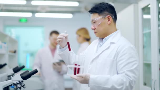 Ιατρικός Ερευνητής Επιστήμονας Ασιάτης Προστασία Κρατώντας Δείγμα Αίματος Hiv Βακτηριακές — Αρχείο Βίντεο