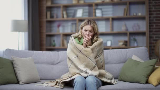 Blonde Mature Woman Frozen Sitting Cold Room Sofa Home Disgruntled — Vídeo de Stock