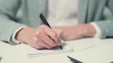 Close up hands of busy concentrated business man financial analyst or freelancer doing paperwork and making notes in notebook at office workplace indoors Planning workday or meeting schedule concept