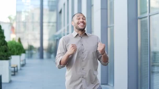 Nadšený Dospělý Muž Oslavující Vítězství Kráčející Ulicí Poblíž Kancelářské Budovy — Stock video