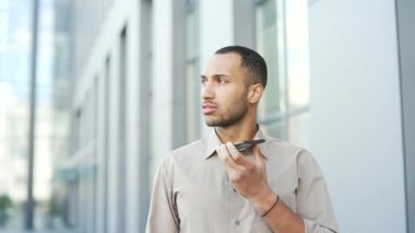 Kapatın. Bir ofis binasının yanında sokakta yürürken akıllı telefondan konuşan genç ve sakin bir işadamı. Elinde telefon tutan ciddi bir erkek iş ortağıyla sohbet ediyor.
