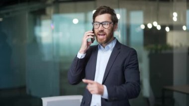 Öfkeli tartışmacı iş adamı patron ofisteki akıllı telefondan bağırıyor sinirli, olgun yatırımcı CEO yönetici telefonda olumsuz duygularını dile getiriyor.