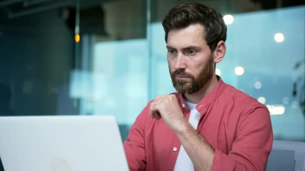 創業の問題を解決し プロジェクトを考えるラップトップコンピュータのビジネスマンに取り組む集中成熟したビジネスマン起業家ガラス現代オフィスの職場で赤いシャツで忙しいハンサムな男性 — ストック動画