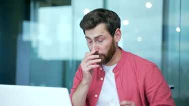 Hasta, sağlıksız iş adamı serbest çalışan, ofiste bilgisayar başında çalışırken burun akıntısıyla hapşıran, soğuk algınlığı ve ateş konsepti yüzünden kendini kötü hisseden, hasta ve sakallı bir işadamı.