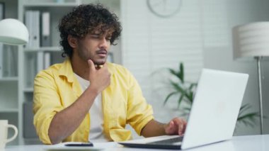 Ofisteki düşünceli ciddi işçiler dizüstü bilgisayarlar üzerinde çalışırlar ılımlı ofislerde ya da ev tasarımcısı mimarlarında ya da serbest tasarımcılarda.