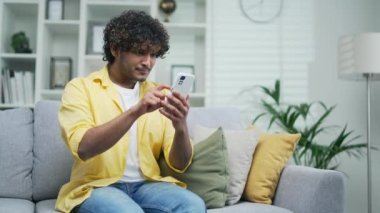 Şaşırtıcı yakışıklı adam SMS mesajı alıyor. Arap mutlu adam akıllı telefondan iyi haberler okuyor. Heyecanlı Hintli erkek kazanan cep telefonu zaferini kutluyor.