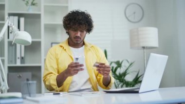 Başarısız ödemeler internet dolandırıcılığı mağduru üzgün Hintli adam ofiste ya da ev sahibi kartı ve akıllı telefon palmiyesi aşırı harcama şok hissetti banka sorunundan çalınan tasarruf parasını kaybetti