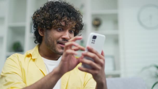Smsメッセージを受け取る素晴らしいハンサムな男は スマートフォンで良いニュースを読んで機会アラビア語幸せな男を提供しています成功を祝う興奮したインドの男性勝者携帯電話の勝利通知 — ストック動画