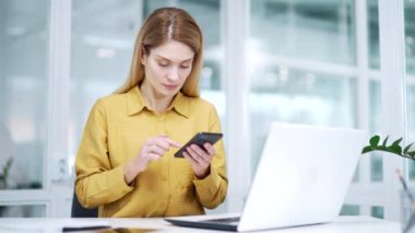 Gergin, sarışın, olgun iş kadınının iş yerinde akıllı telefon kötü hizmetiyle ilgili sorunları var. Stresli girişimci, cep telefonu kullanıyor. Kapalı alanda uygulama uygulamasında herhangi bir bağlantı hatası yok.