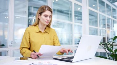 Şirketin istatistik grafikleri ile pazarlama araştırması yapan ve cam ofisindeki dizüstü bilgisayardaki elektronik dijital veritabanına veri girmekle meşgul.