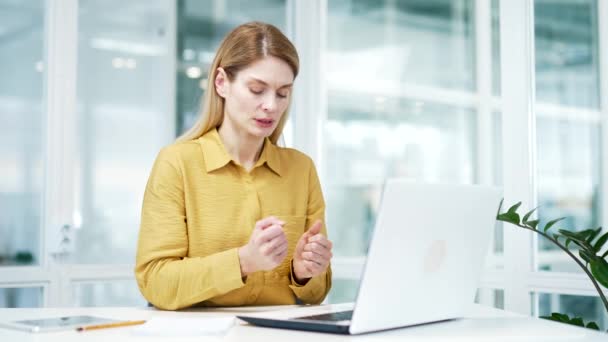 現代の職場でノートパソコンで過労入力しながら重度の手首の痛みを感じる排出成熟したビジネス女性ガラスオフィスで関節痛外傷に苦しむ疲れマッサージ手をブロンド — ストック動画