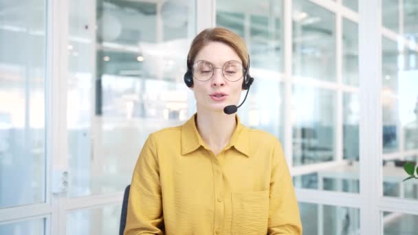在现代玻璃工作场所 拥有无线耳机 看着摄像机 通过在线会议视频求助热线交谈的成熟商界女性支持经理的相机照片 — 图库视频影像