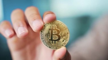 Altın bir bitcoin tutan bir adamın eline yaklaş. Zengin adam altın parayı tutar ve gösterir. İnternetteki kripto para ticareti ve dijital yatırımlar. Küresel engelleme teknolojisi Finans kavramı