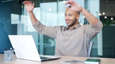 Genç ve mutlu iş adamı teneffüste ellerini başının arkasında uzatarak modern ofiste iş yerinde oturuyor. Ofis çalışanı dizüstü bilgisayarla işini bitirdi, huzuru buldu. Ve ara veriyor.