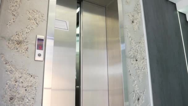 シャツを着たアフリカ系アメリカ人実業家がモダンなオフィスビルのエレベーターを出る 事務所の廊下を歩いている間にスマートフォンで話している執行役員を自信を持って — ストック動画