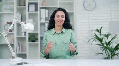 Web kamerası görüntüsü, kameraya bakıp online konferans videosuyla konuşan genç çalışan işkadını modern ofis işyerinde sohbet ederken kapalı alan Webinar öğretmeni