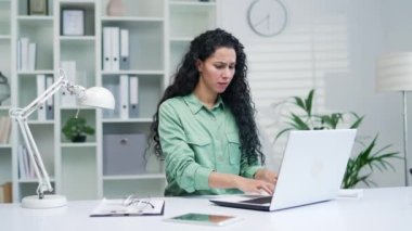 Sinirli genç bir kadın dizüstü bilgisayara bakıyor, kötü düşük internet bağlantısından rahatsız oluyor ofis evinde uzaktan çalışan stresli bir kadın zor iş ya da sistem çökmesi nedeniyle mutsuz.