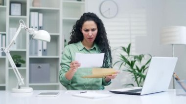 Kadın açık mektup zarfı, kötü haberlerle dolu. Ofis işyerinde oturan olumsuz sonuçlu bir tebligat. Ödeme vergisi faturası ya da iflas ihtarı için banka borcu faturası.