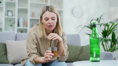 Sarhoş, olgun, sarışın, alkol içen bir kadın evdeki oturma odasında oturuyor. Yorgun ve üzgün bir kadın masanın önünde elinde şişe viski tutarken sorunları düşünüyor.