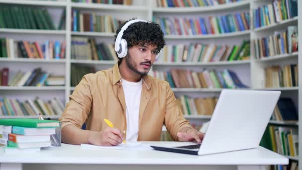 Estudante Universitário Jovem Usando Fones Ouvido Estudando Enquanto Assiste Webinar — Vídeo de Stock