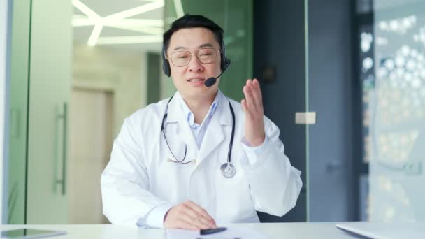 Widok Kamery Azjatycki Lekarz Słuchawkach Rozmawiający Przez Wideo Połączenie Pomocą — Wideo stockowe