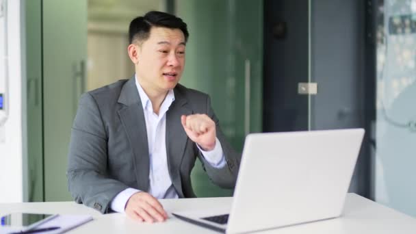 Homem Negócios Asiático Falando Uma Chamada Vídeo Usando Laptop Enquanto — Vídeo de Stock