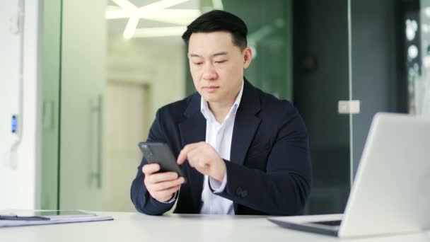 Frustrated Asian Man Having Problems Software Service Smartphone While Sitting — Stock Video