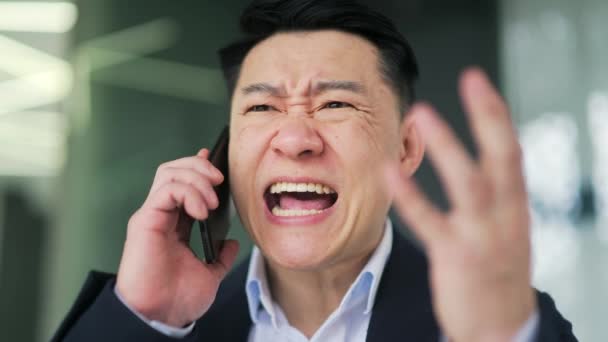 Cerca Enojado Hombre Asiático Traje Formal Discutiendo Mientras Habla Teléfono — Vídeos de Stock