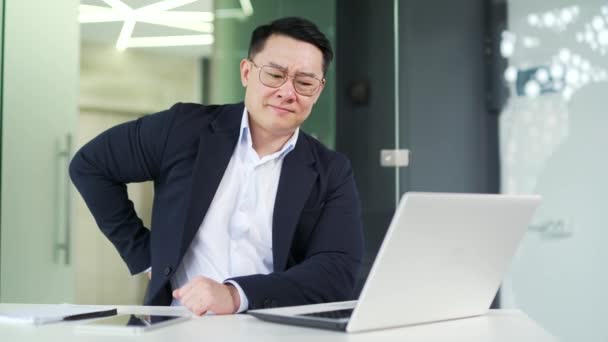 Asijský Muž Trpí Bolestí Zad Při Práci Notebooku Zatímco Sedí — Stock video