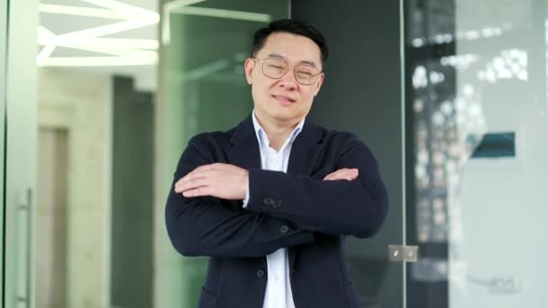 Portret Uśmiechniętego Azjatyckiego Biznesmena Formalnym Garniturze Okulary Stojące Nowoczesnym Biurze — Wideo stockowe