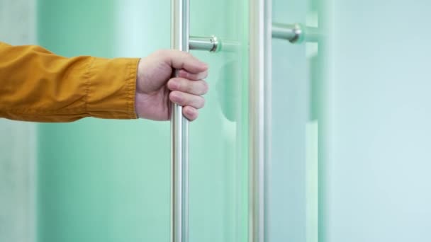 Zamknij Dłoń Mężczyzny Otwierającego Szklane Drzwi Biurowe Trzymając Metalową Klamkę — Wideo stockowe