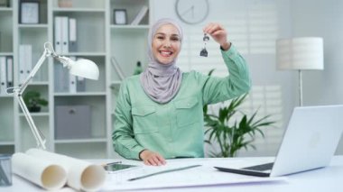 Müslüman kadın emlakçı elinde modern ofis binasının anahtarını tutuyor. Mali konut kredisi ya da ev satın almak için biriktirilen para, gayrimenkul ve sigorta tasarımcısı ya da mimar.