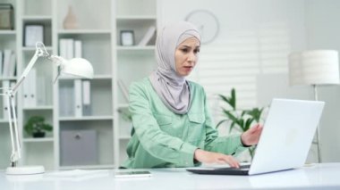 Sinirli genç bir kadın dizüstü bilgisayara bakıyor, kötü düşük internet bağlantısından rahatsız oluyor ofis evinde uzaktan çalışan stresli bir kadın zor iş ya da sistem çökmesi nedeniyle mutsuz.