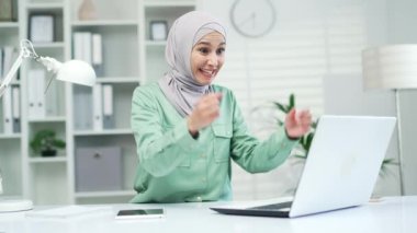 İş yerindeki bilgisayardan gelen mesajı okuduktan sonra çok mutlu genç bir iş kadını. Heyecanlı bir çalışan, ekrana bakıyor ve ofisin içinde sevinçle karşılanıyor.