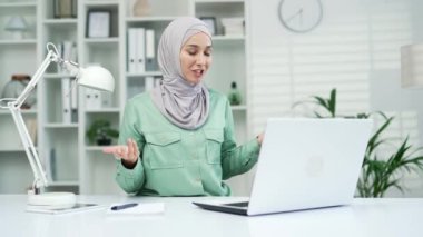 Genç çalışan işkadını konferans videosuyla konuşuyor. Modern ofis işyerinde sohbet ediyor. Uzaktan iletişim için dizüstü bilgisayar kullanarak kapalı dokuma öğretmeni danışmanı.