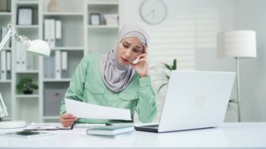 Kağıt işlerinden bıkmış Müslüman kadın muhasebeci ya da girişimci ofisteki iş yerinde aşırı çalışan serbest çalışan, hataya düşmüş kağıt dökümanındaki yanlış bilgi 